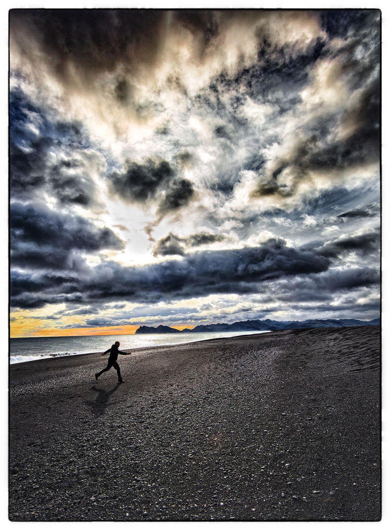 a-man-is-silhouetted-by-the-late-fall-afternoon-sun-as-he-runs-on-the-beach-in-western-iceland