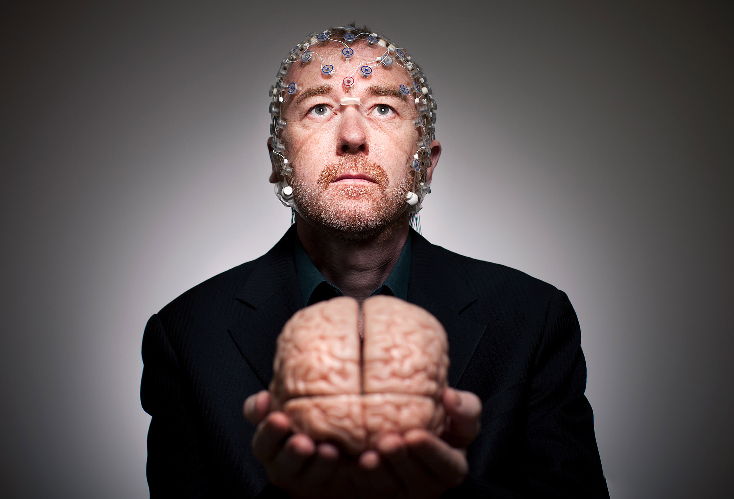 doctor adrian owen from  londons western university holds a model of a brain in his hands