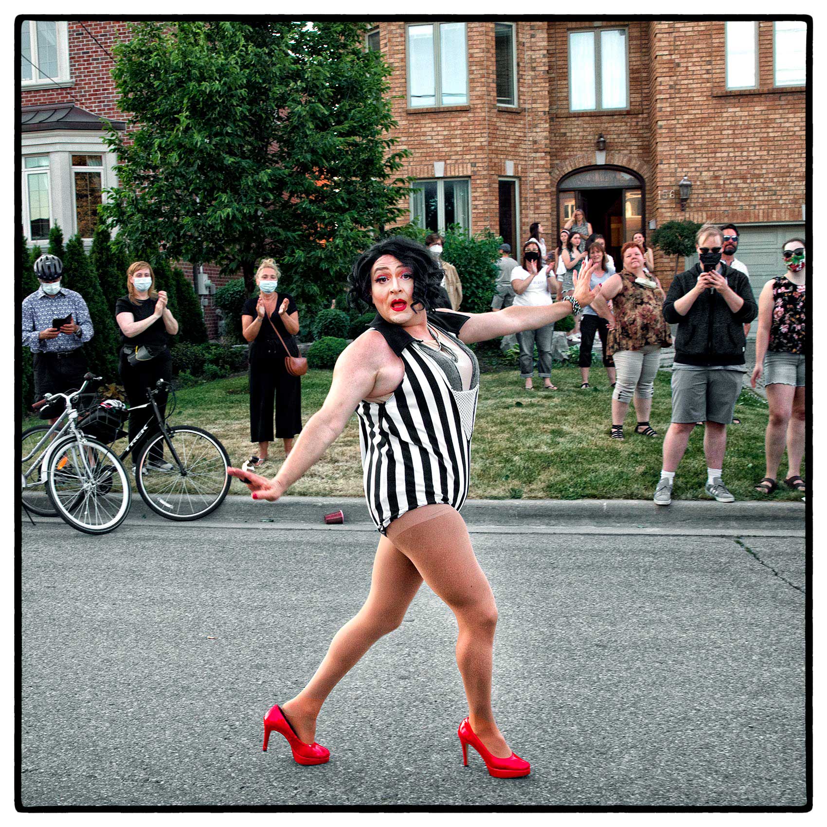 a drag queen dances down a suburban street in north york during covid 19