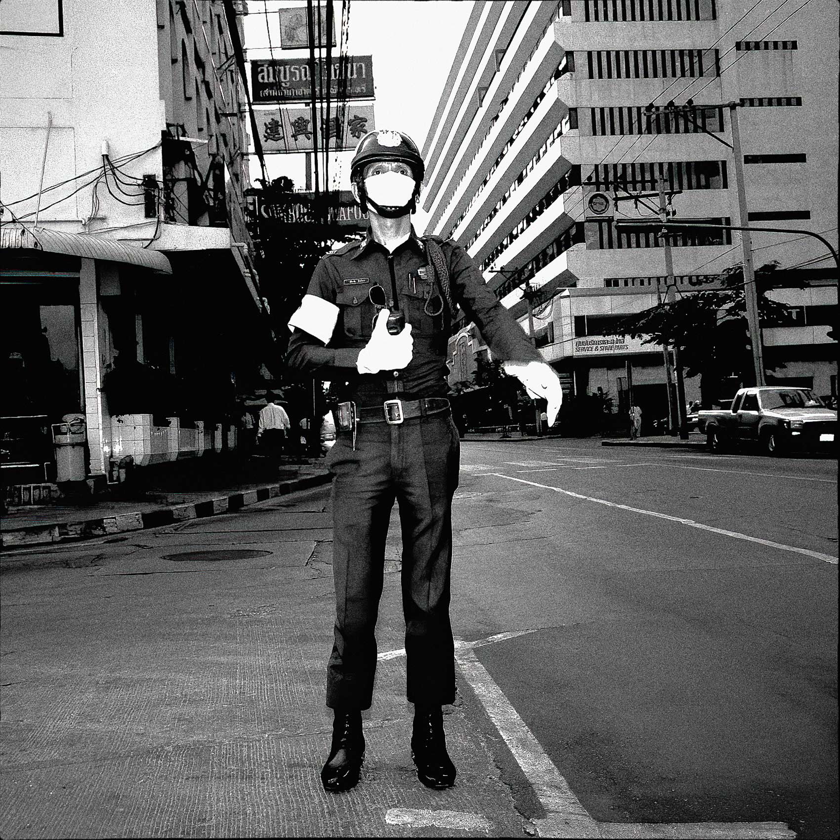 a-bangkok-policeman-wearing-a-face-mask-directs-traffic-in-the-downtown-core-of-the-city