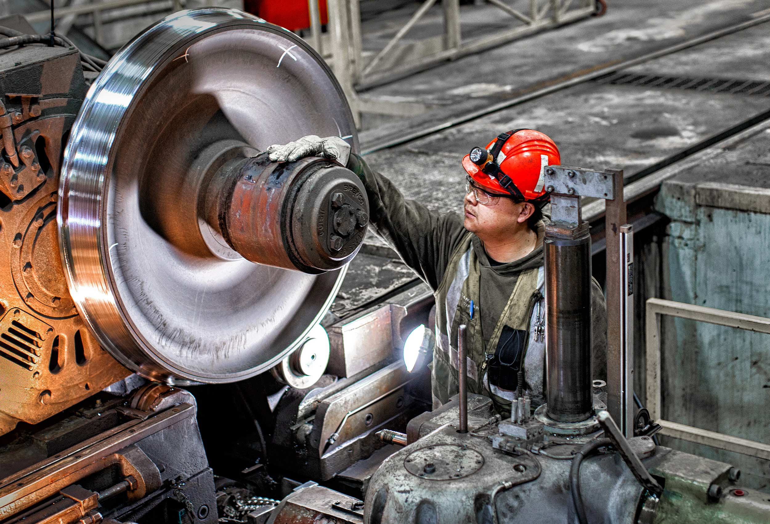 a cp rail engineer inspects an industrial  locomotive rail wheel at the ogden dale yard in calgary