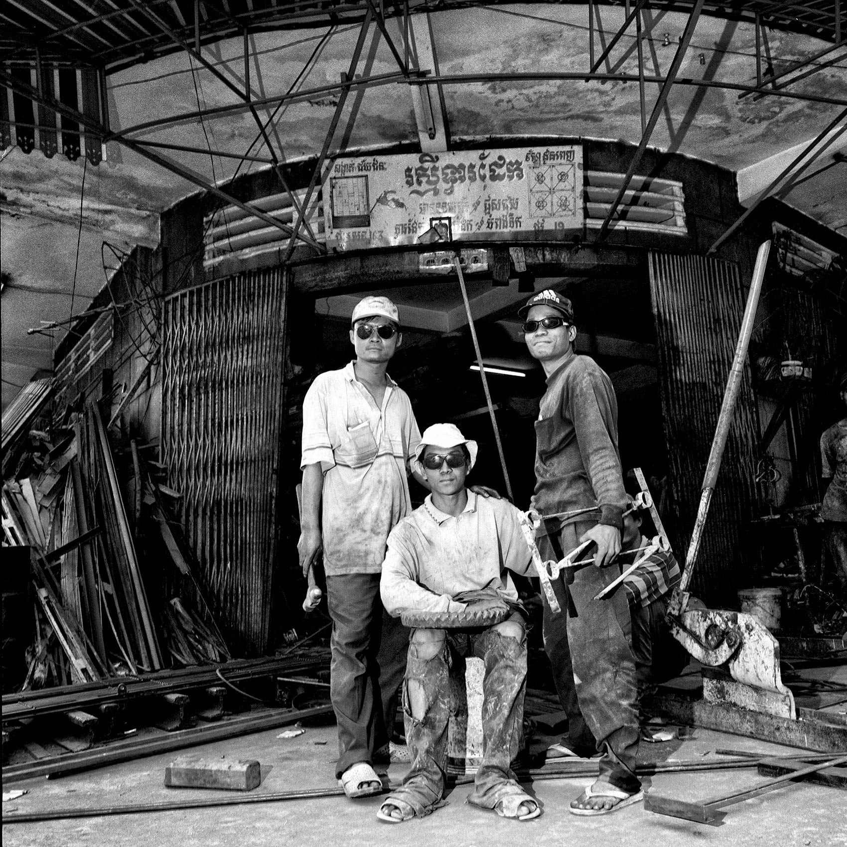 a-group-of-welders-pose-outside-their-shop-in-phnom-pehn-cambodia