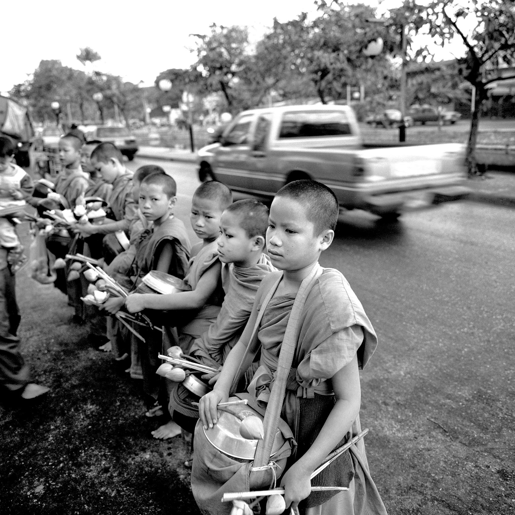 a-group-of-young-boy-monks-stand-in-a-group-on-a-thai-street