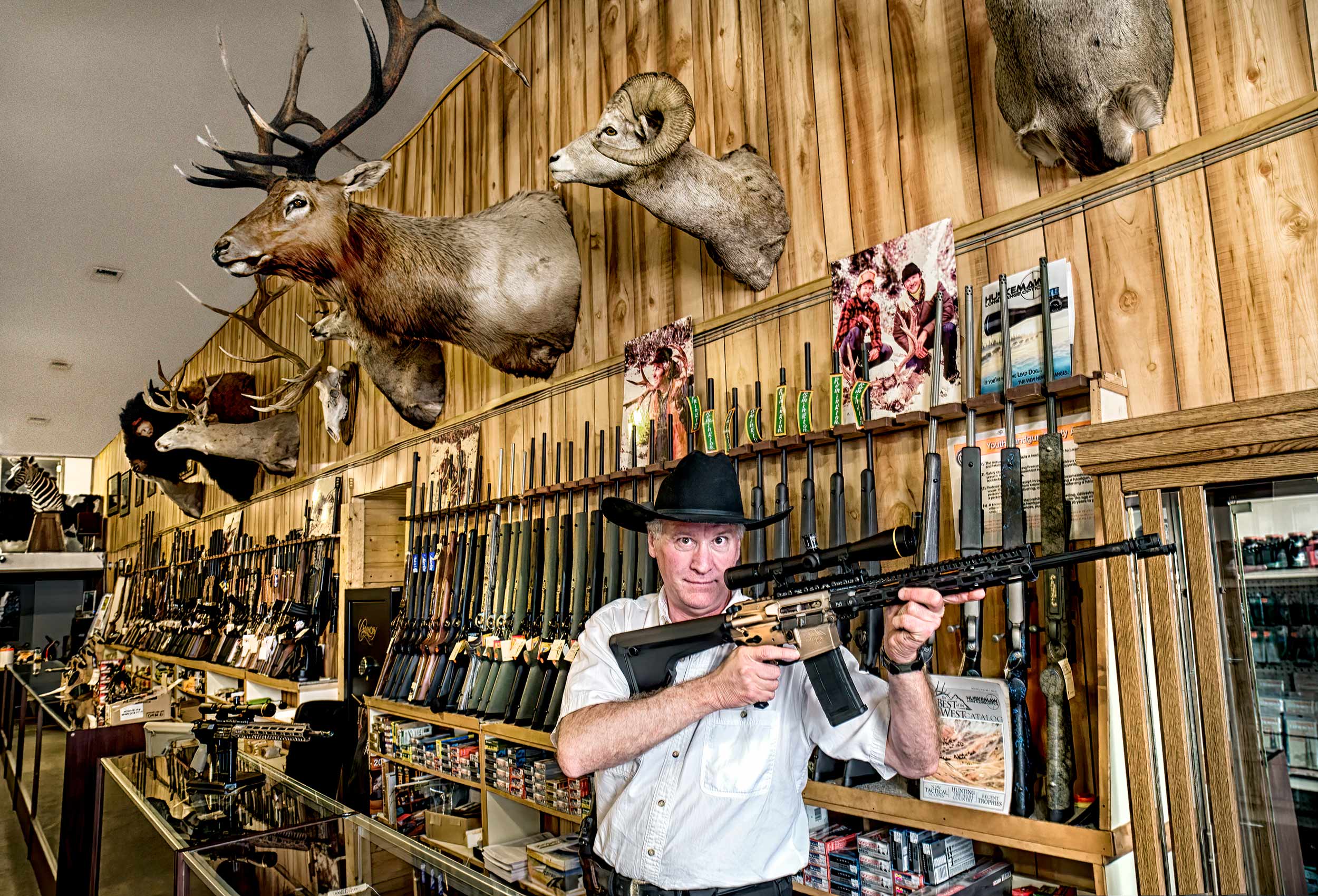 a gun shop owner brandishes a rifle inside his store in cody wyoming
