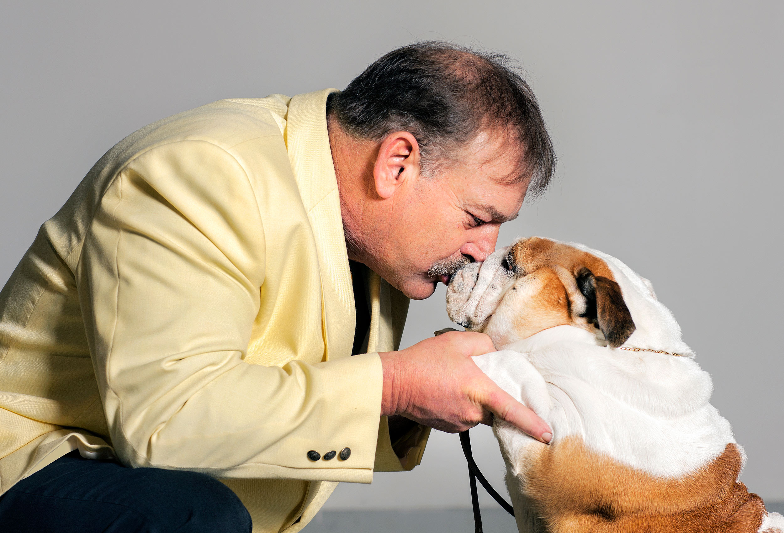 a-man-at-a-dog-show-kisses-his-pet-bulldog-after-he-pulls-off-a-winning-performance