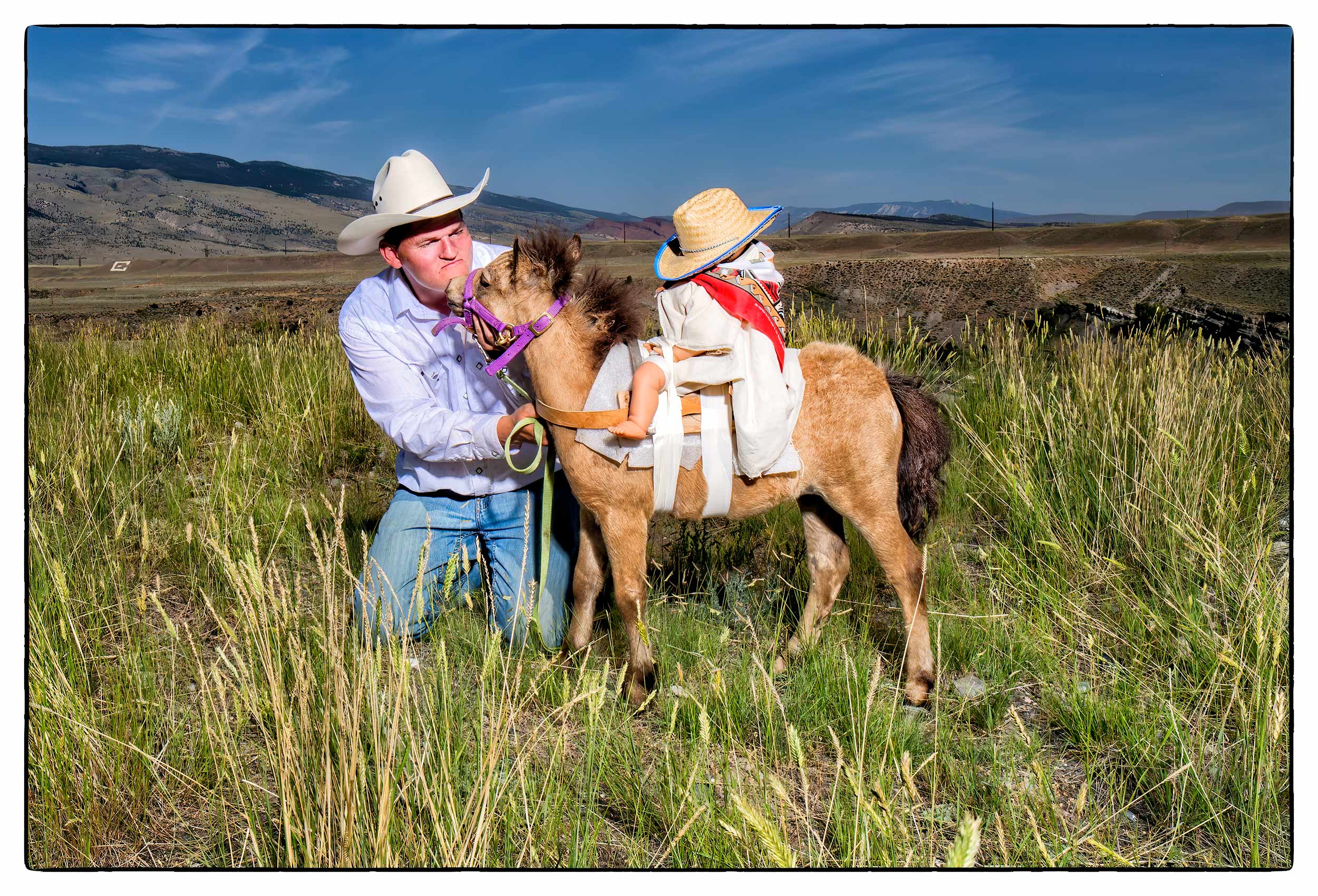a-man-gets-kissed-by-a-miniature-donkey-in-a-field-in-cody-wyoming-usa