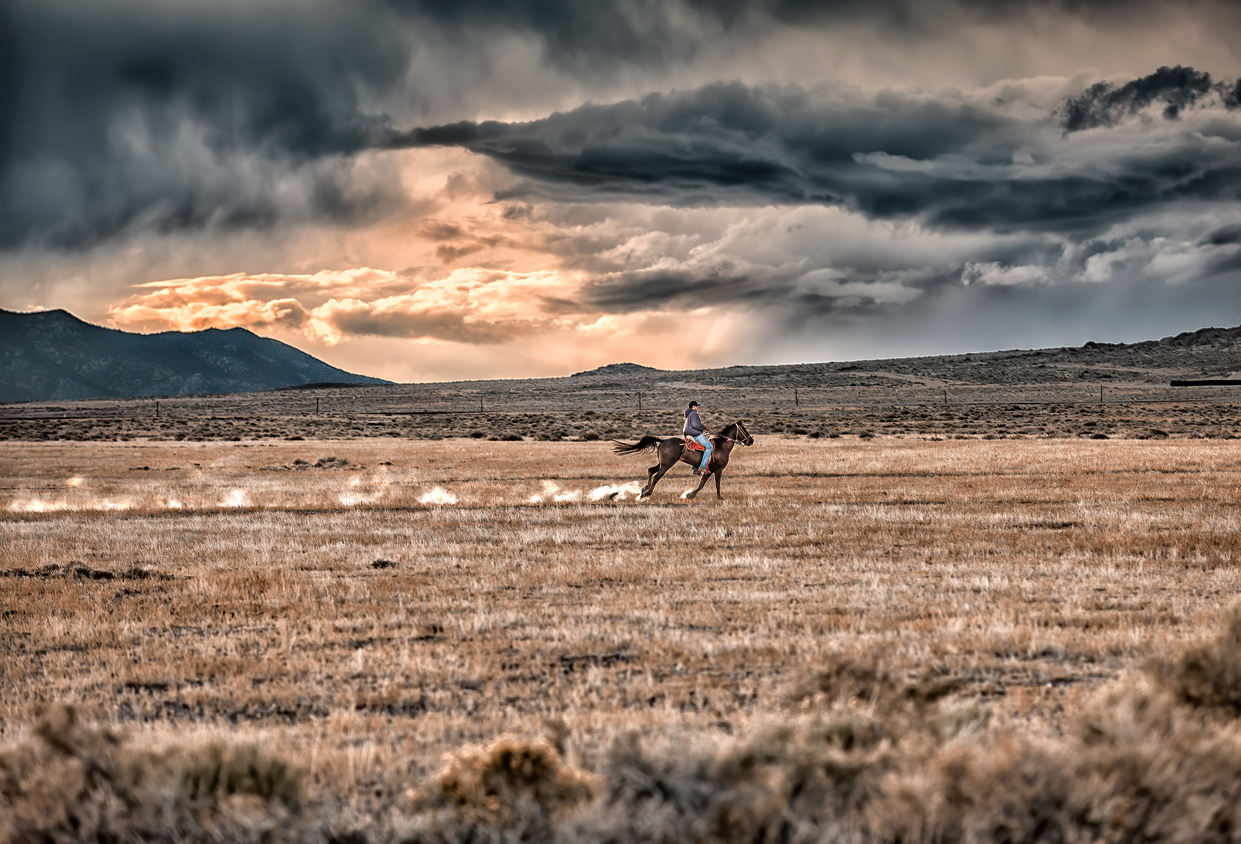 a man on horseback rushes home to beat an incoming summer storm in central nevada