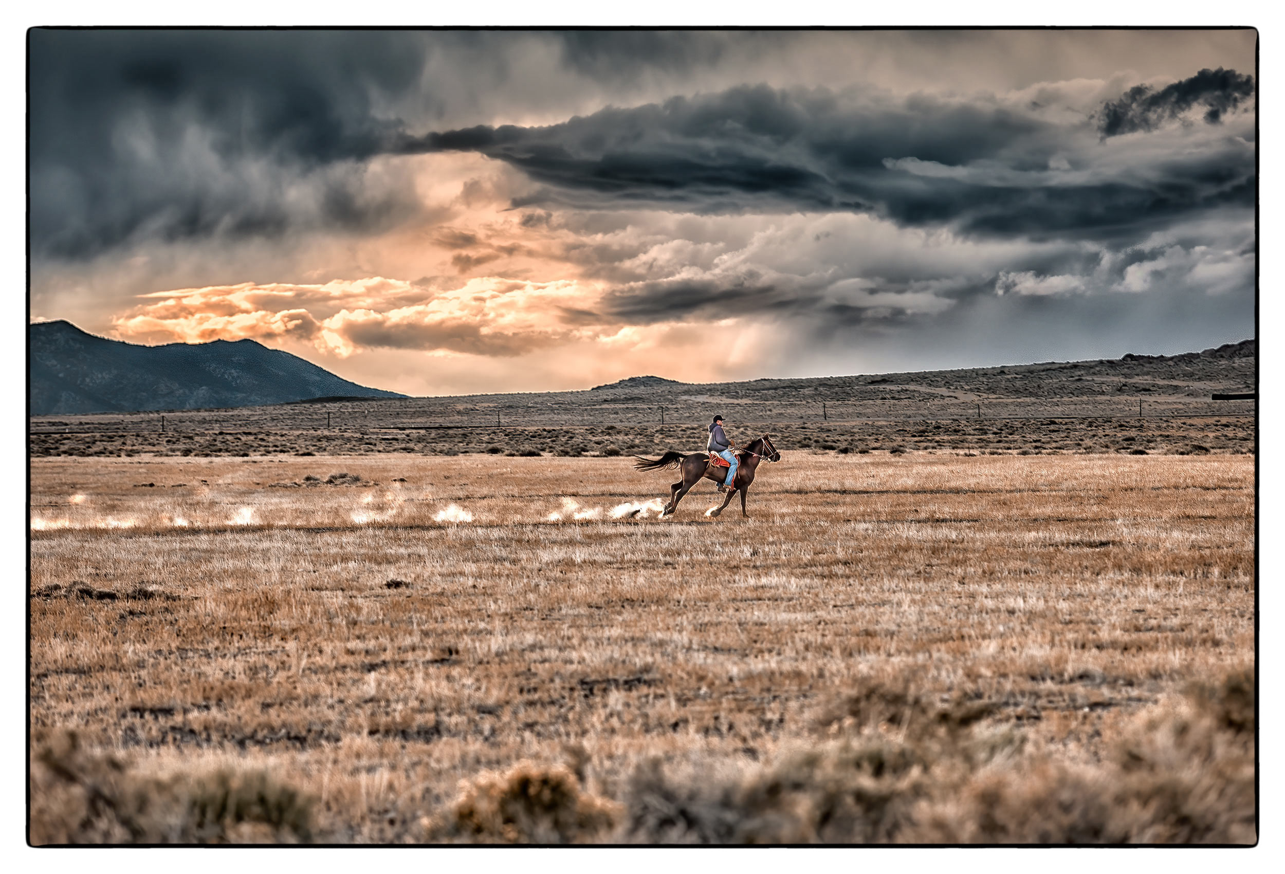 a-man-on-a-horseback-rush-back-to-their-farm-to-beat-an-approaching-storm-in-the-nevada-desert
