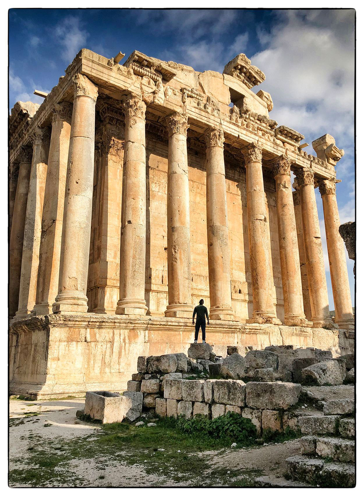 a-man-stands-on-ruins-and-is-silhouetted-against-a-temple-at-baalbek-in-lebanon