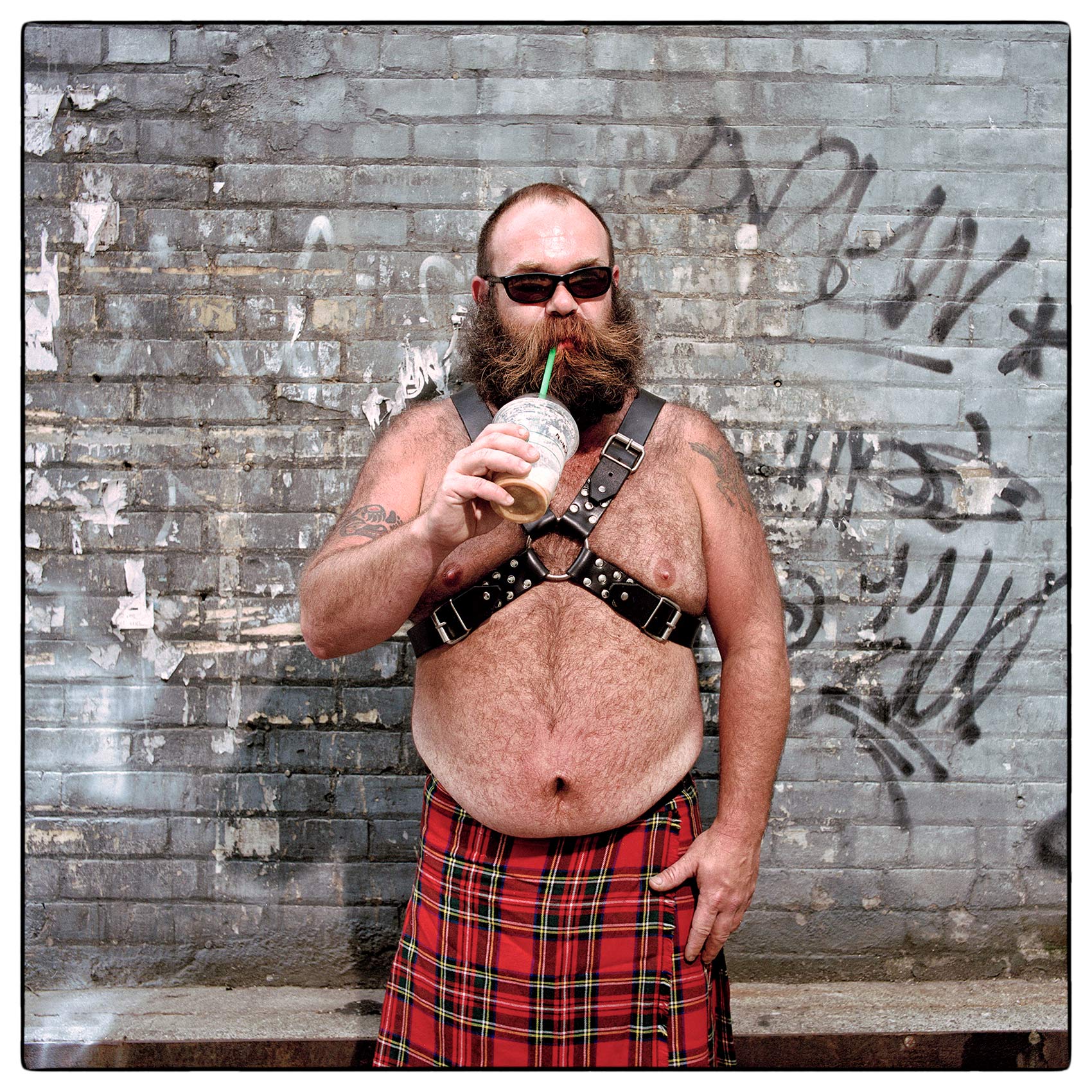 a-man-with-a-beard-dressed-in-a-kilt-poses-for-a-photo-during-toronto-pride