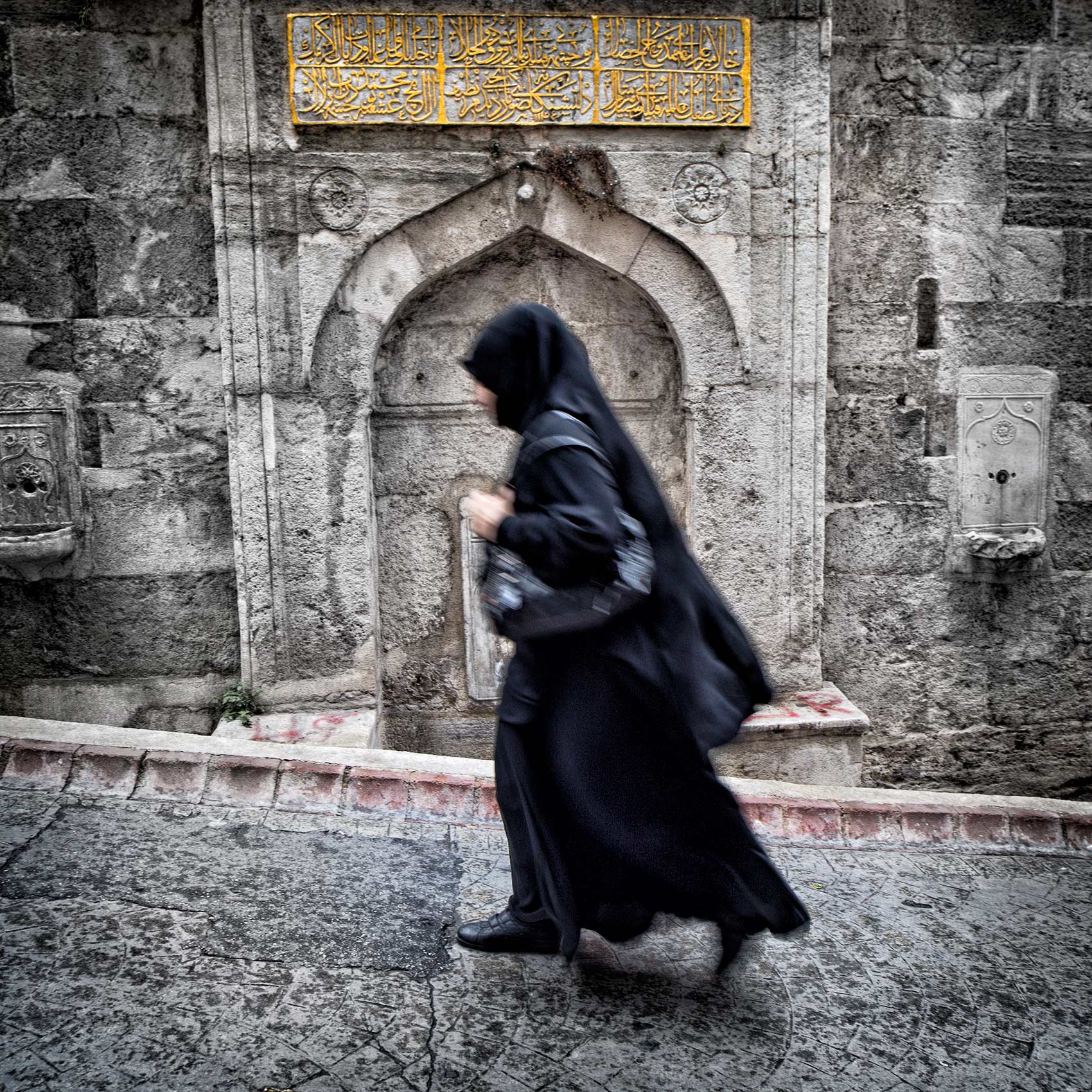 a-muslim-woman-walks-up-a-hill-in-the-beyoglu-district-of-istanbul