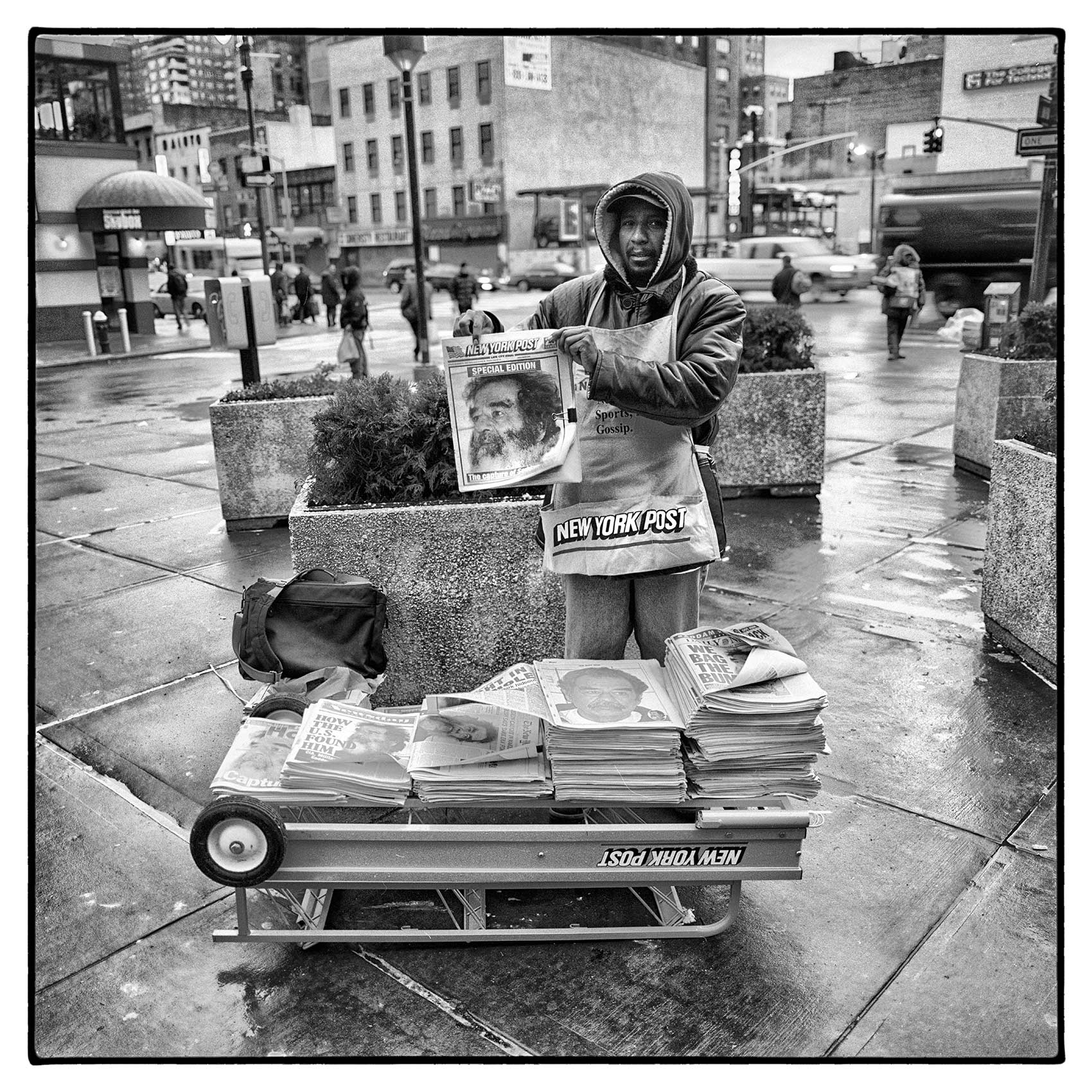 a-new-york-newspaper-vendor-holds-up-a-front-page-that-saddam-hussein-was-captured