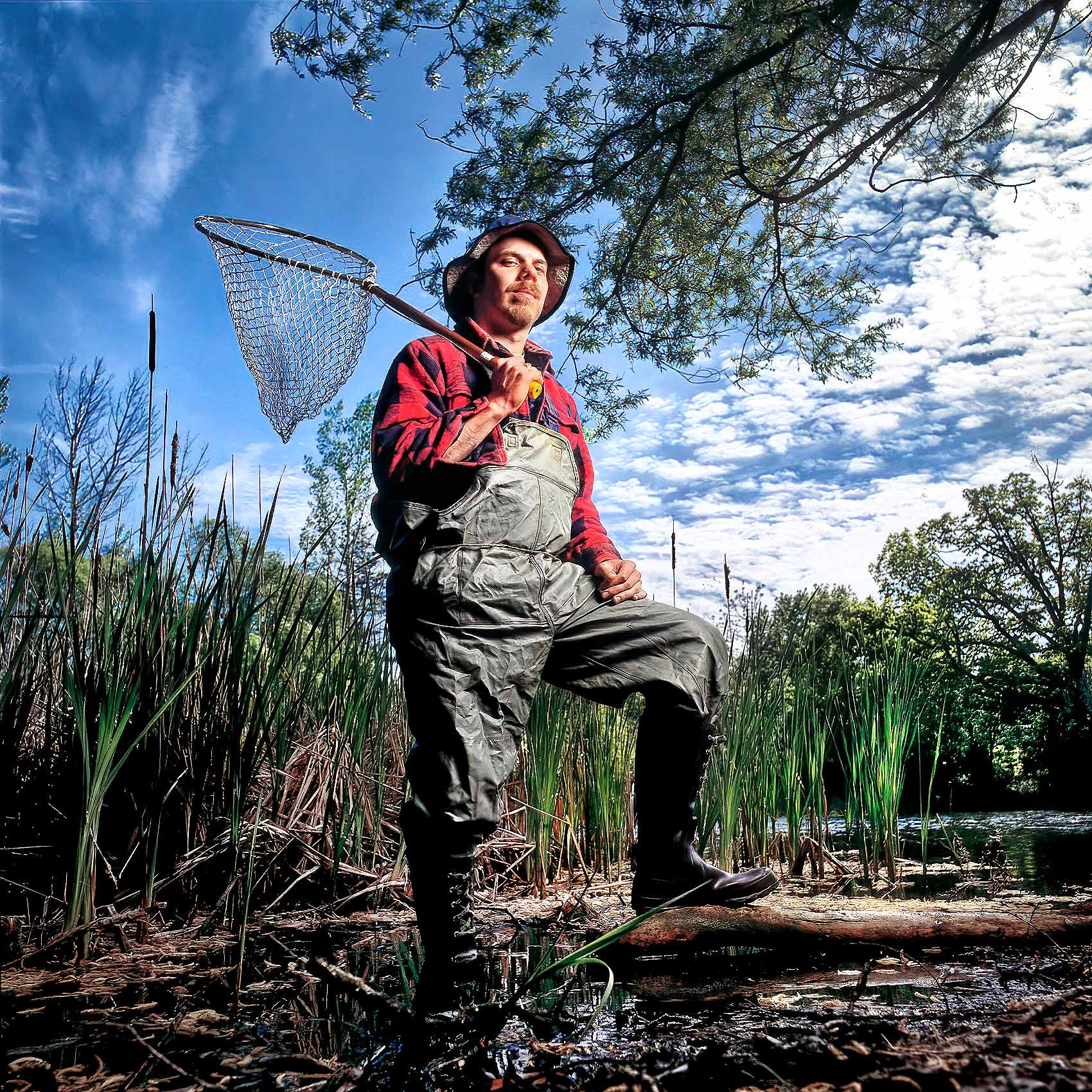 a university of toronto scientist stands in a pond outside the mississauga campus