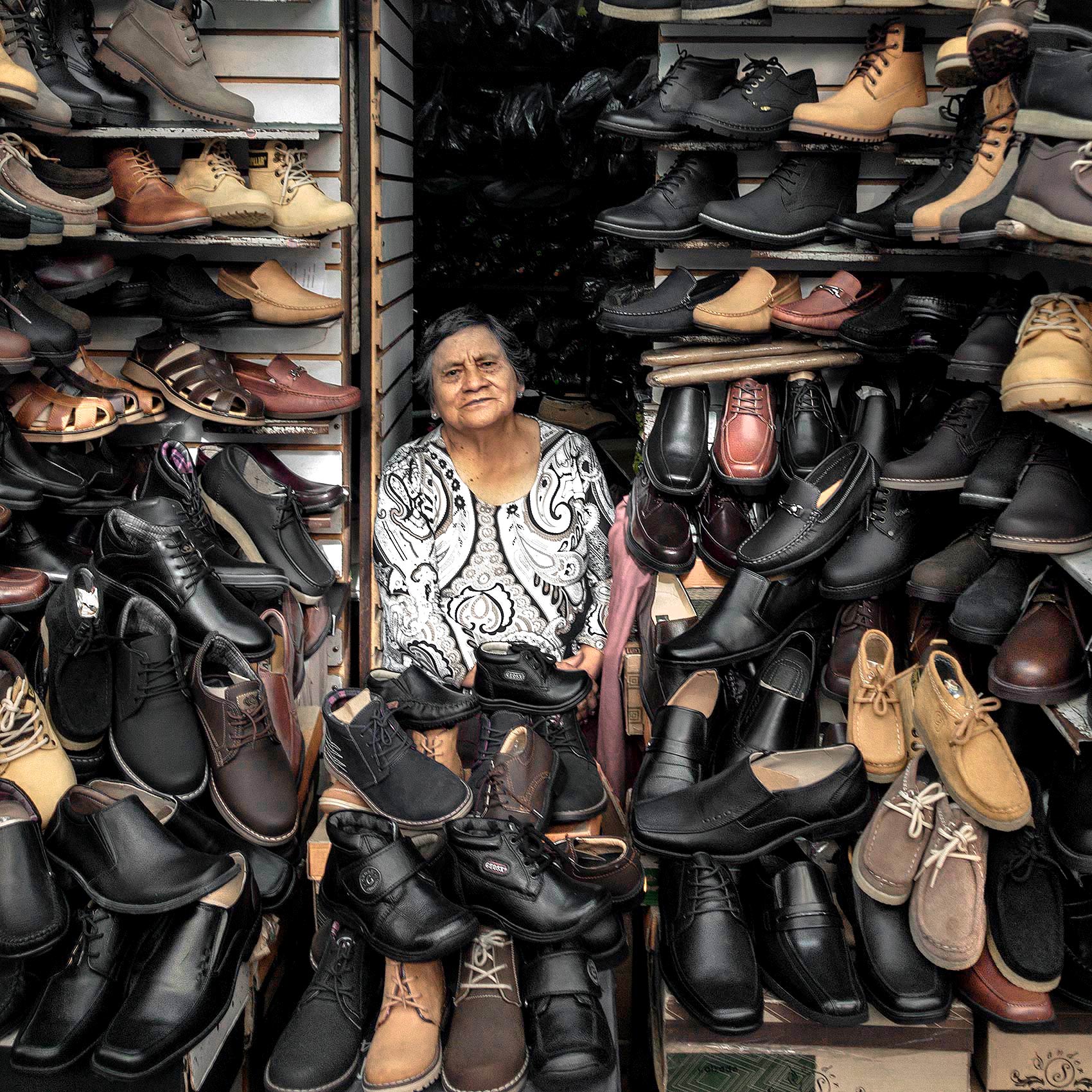 a-shoe-shop-owner-sits-amongst-her-shoes-in-quito-ecuador