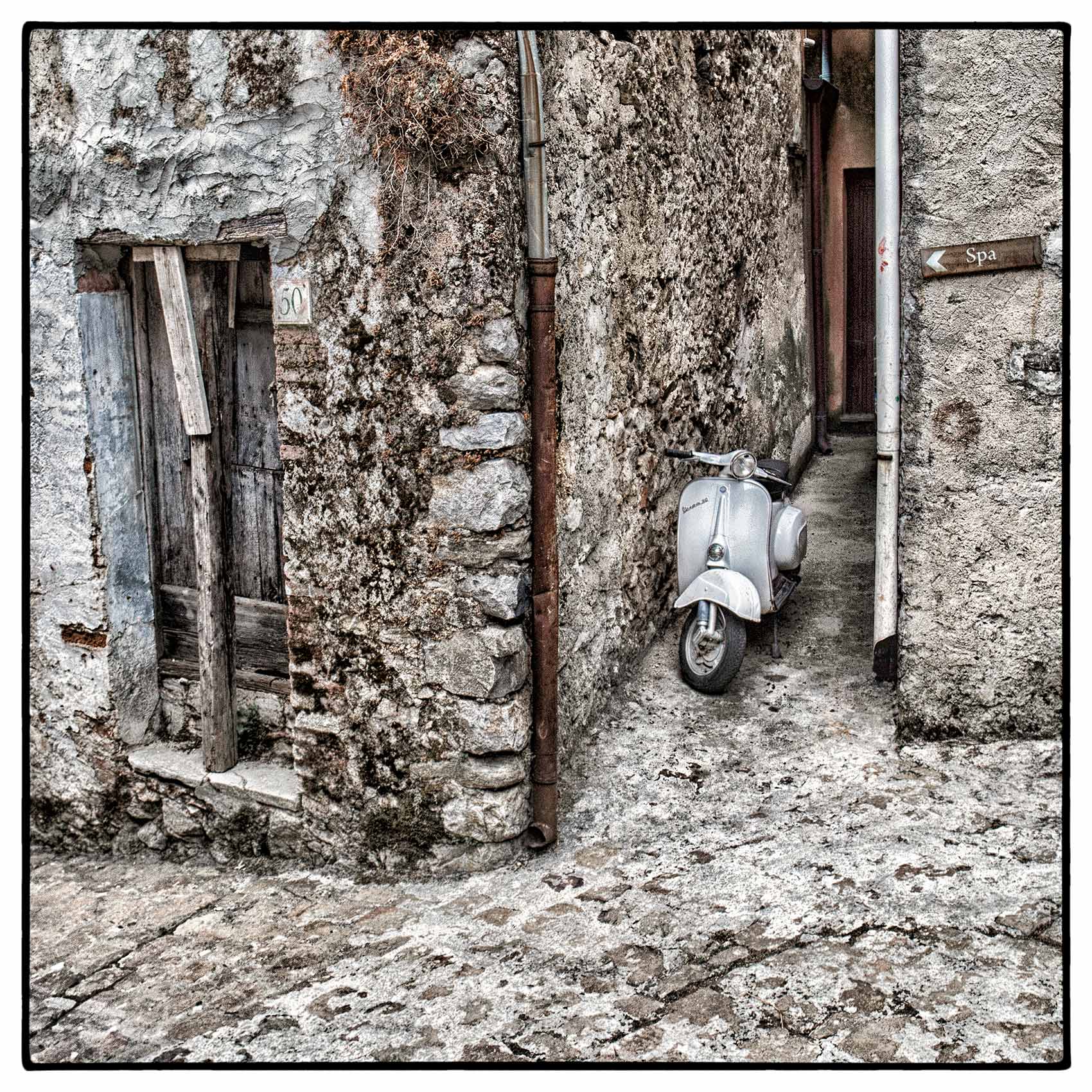 a-vespa-scooter-stands-in-an-alley-way-in-graterri-siciliy-italy