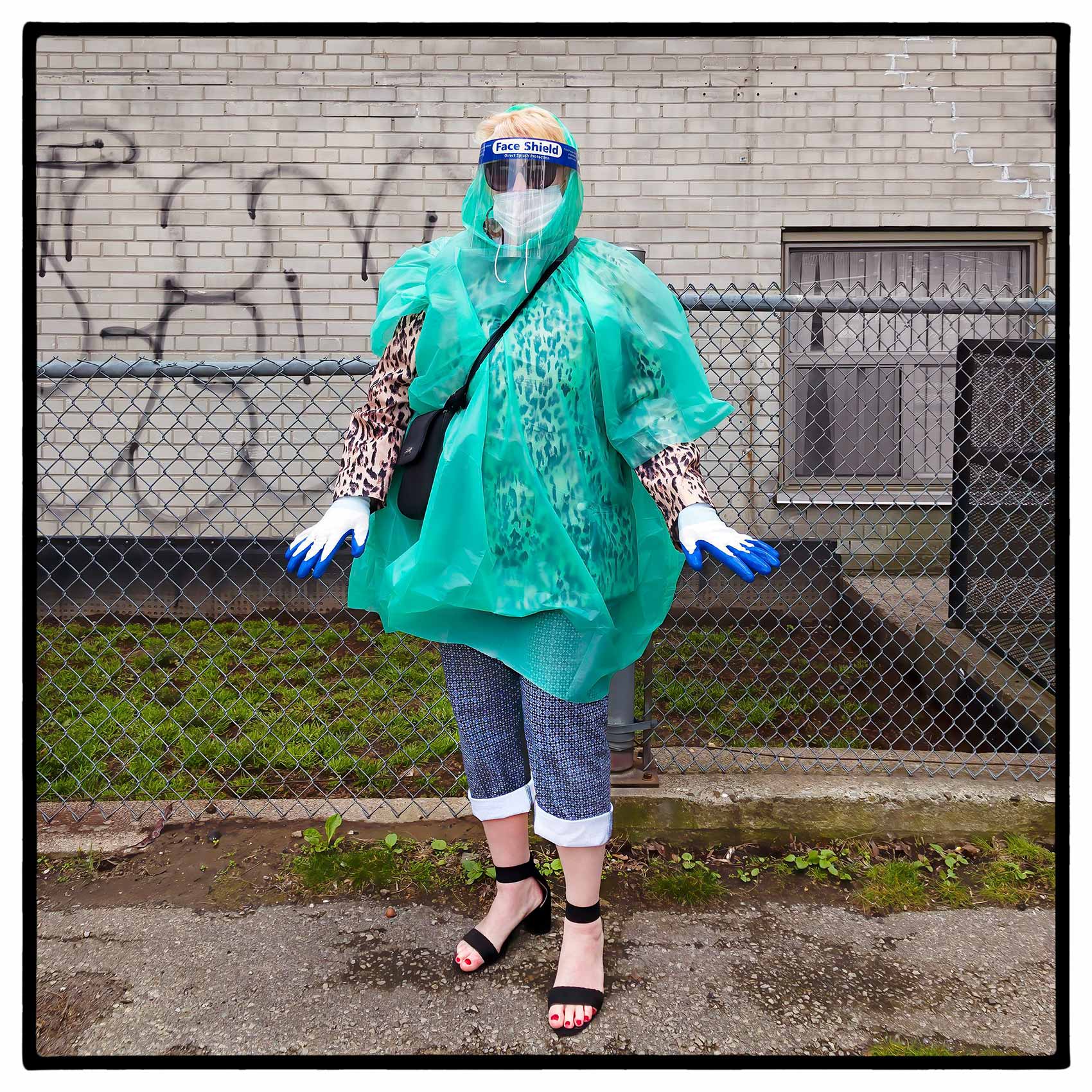 a woman shows off her personal protective equipment outside a toronto store during the pandemic