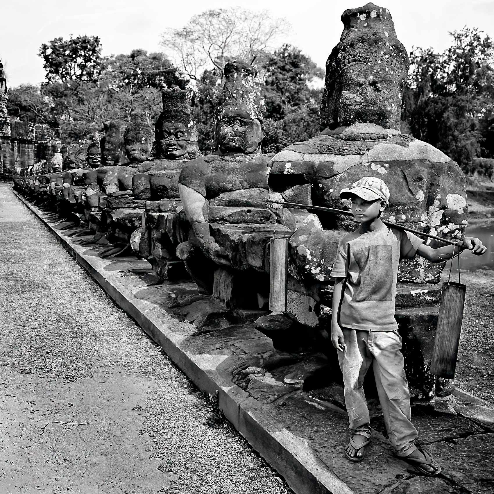 a-young-boy-stands-at-the-entrance-to-angkor-wat-palace-in-cambodia