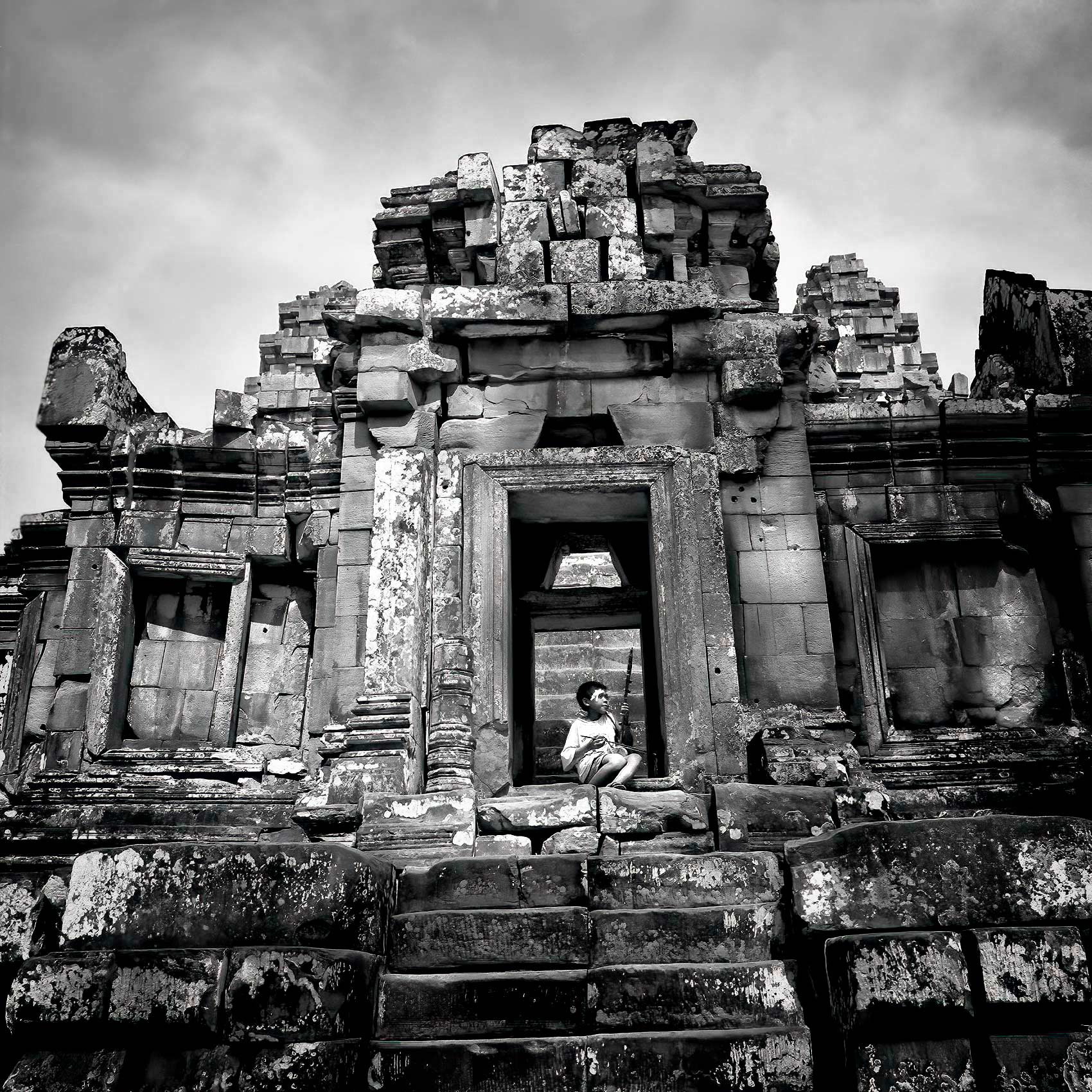 a-young-boy-plays-an-erhu-as-he-busks-for-money-on-the-stairs-of-a-temple-in-angkor-wat