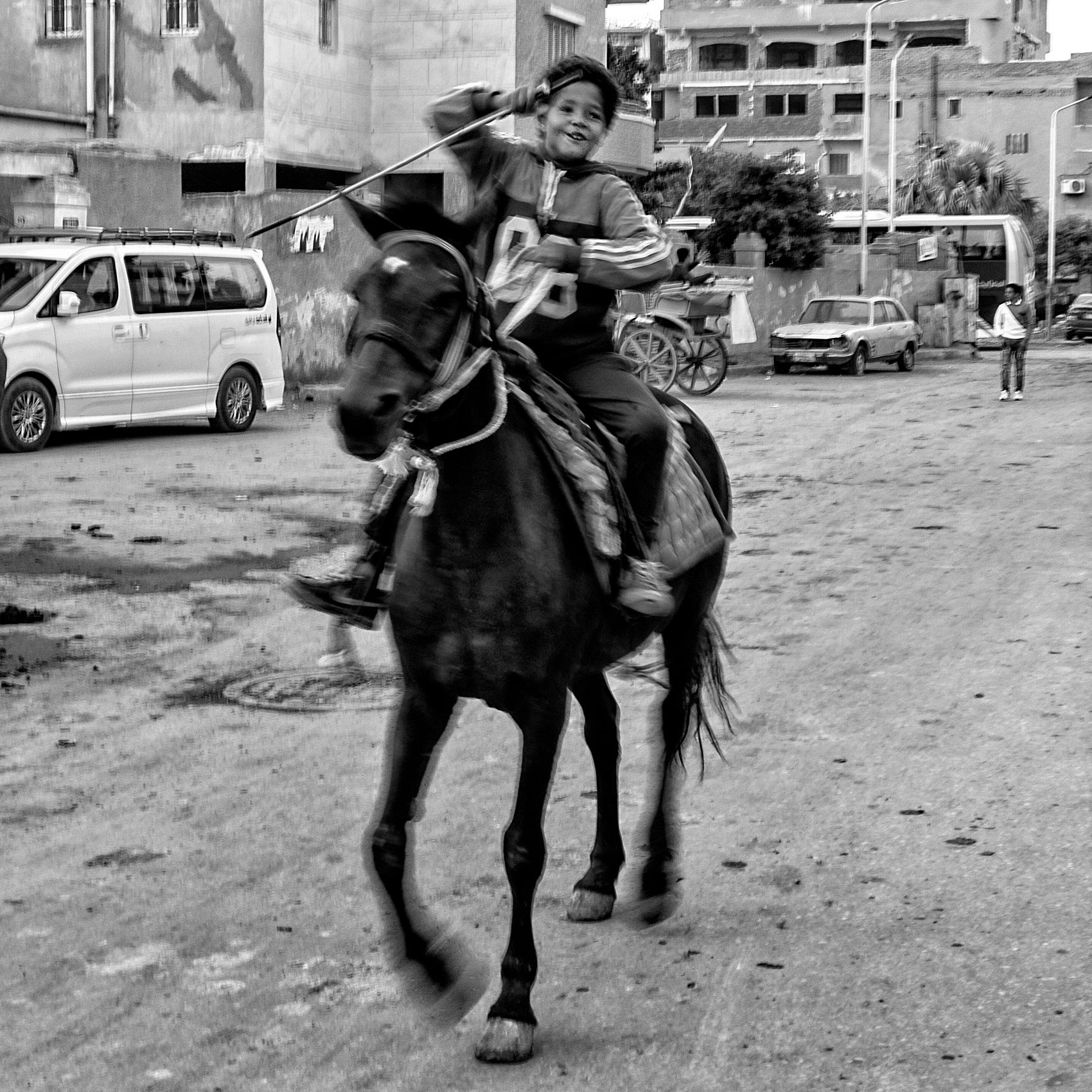 a young boy laughs while riding a horse on the streets of giza egypt