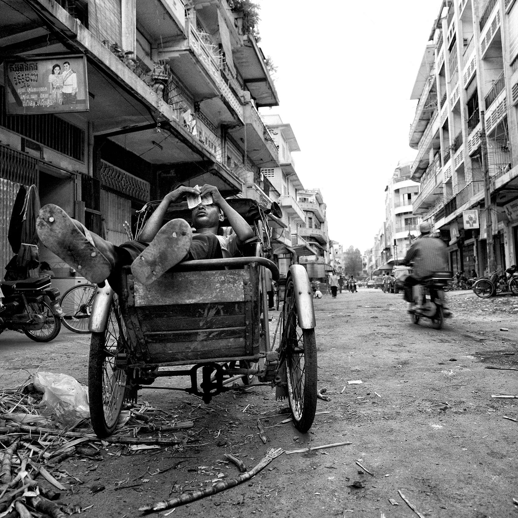 a-young-boy-takes-a-break-as-he-rests-inside-his-bicycle-taxi-in-phnom-penh-cambodia
