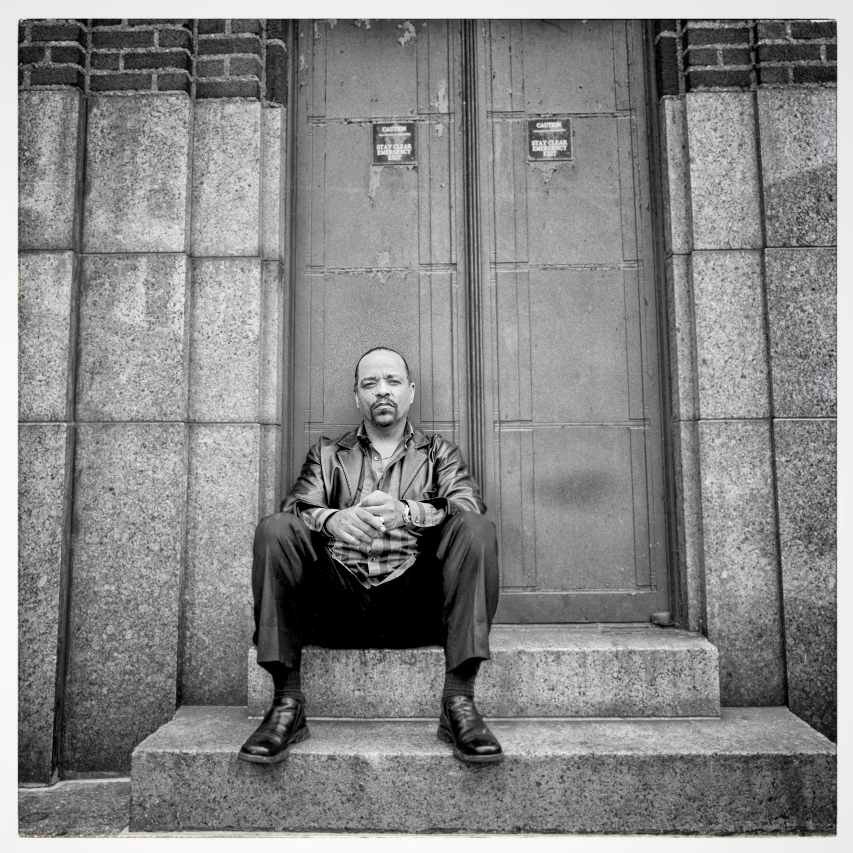 actor ice t sits on the steps of a building in a black and white photo in central manhattan