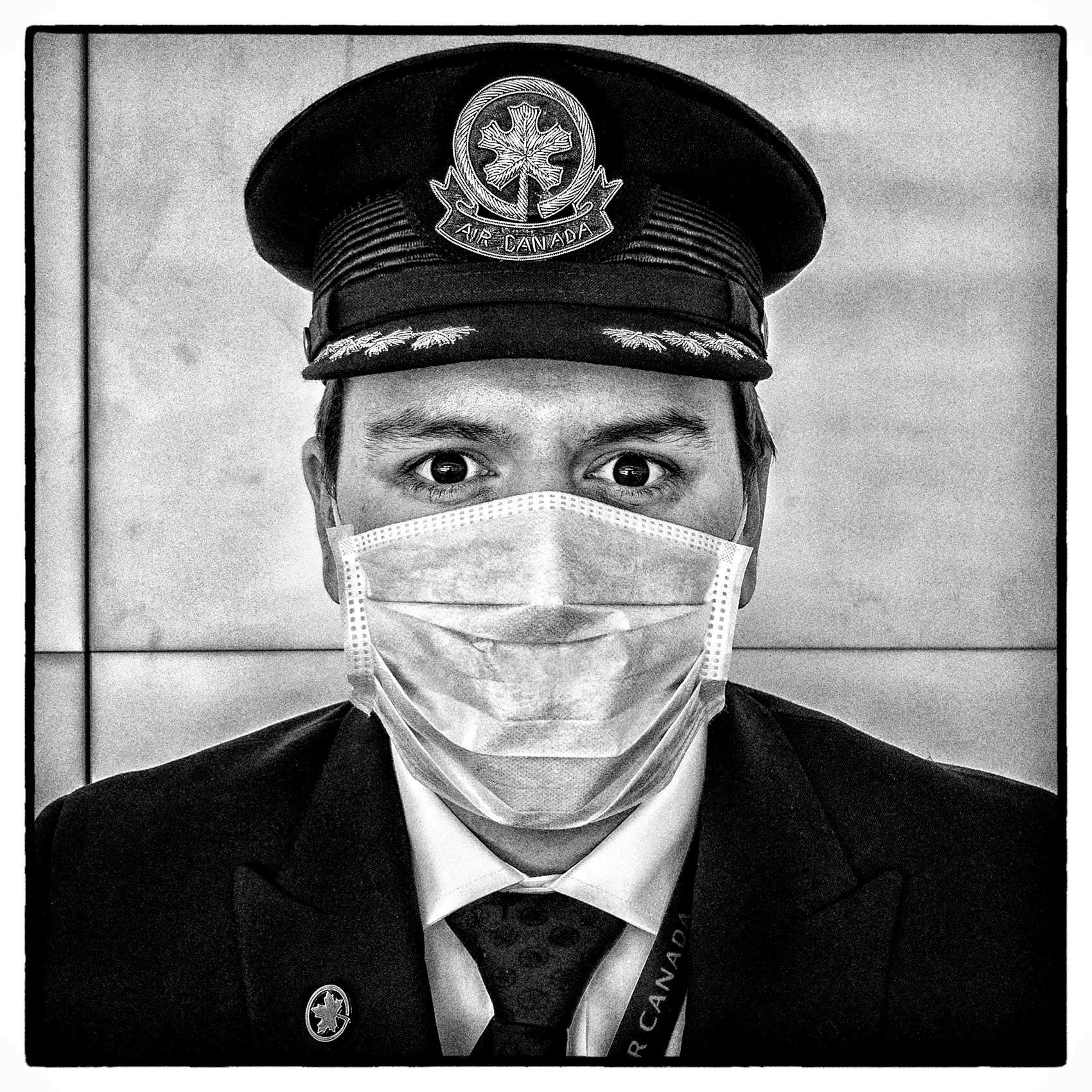 a portrait of a toronto pilot wearing a face mask during the pandemic