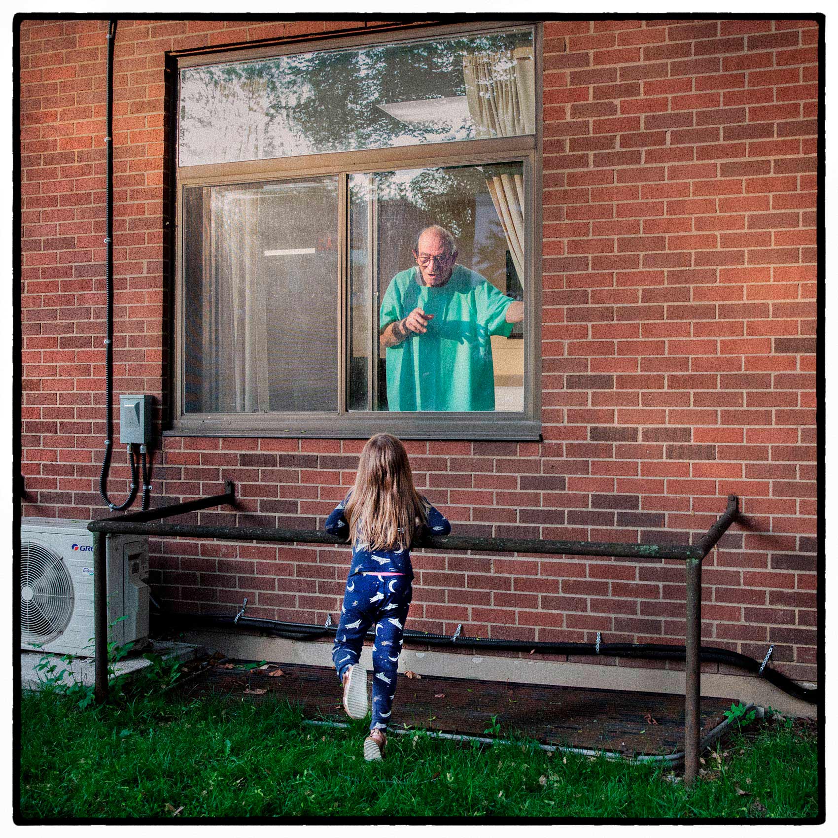 a young girl communicates with a toronto nursing home resident outside his room during the pandemic i