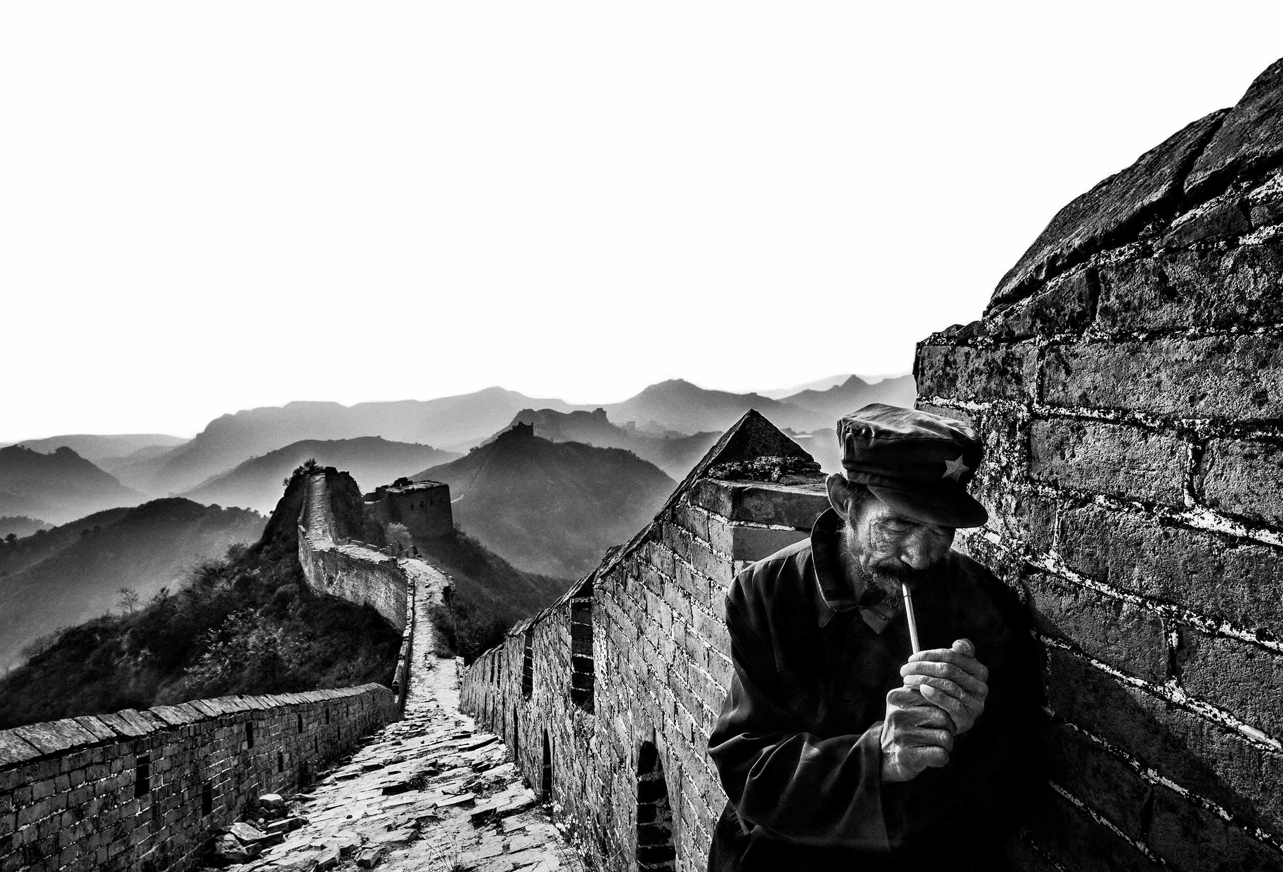  a guard smokes  his pipe on the great wall in simatai china