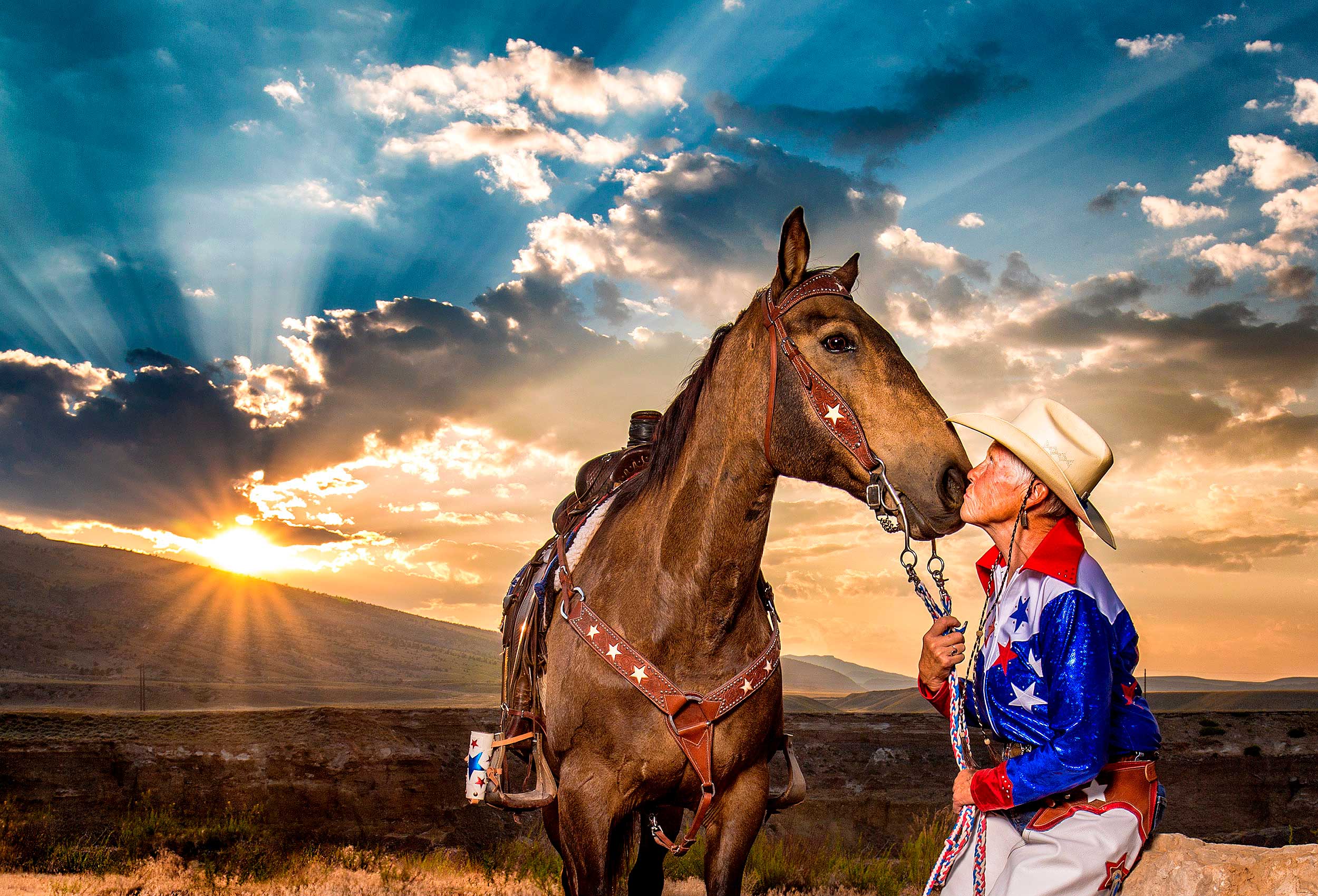 a sunset  portrait of one of the original cowgirl up rodeo drill team members in cody wyoming