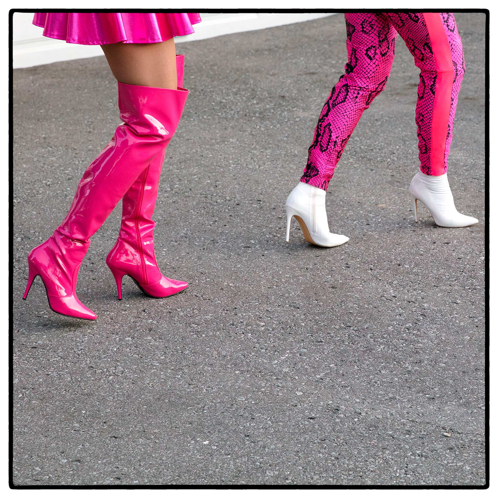 two drag queens walking in pink heels during a performance outdoors in north york