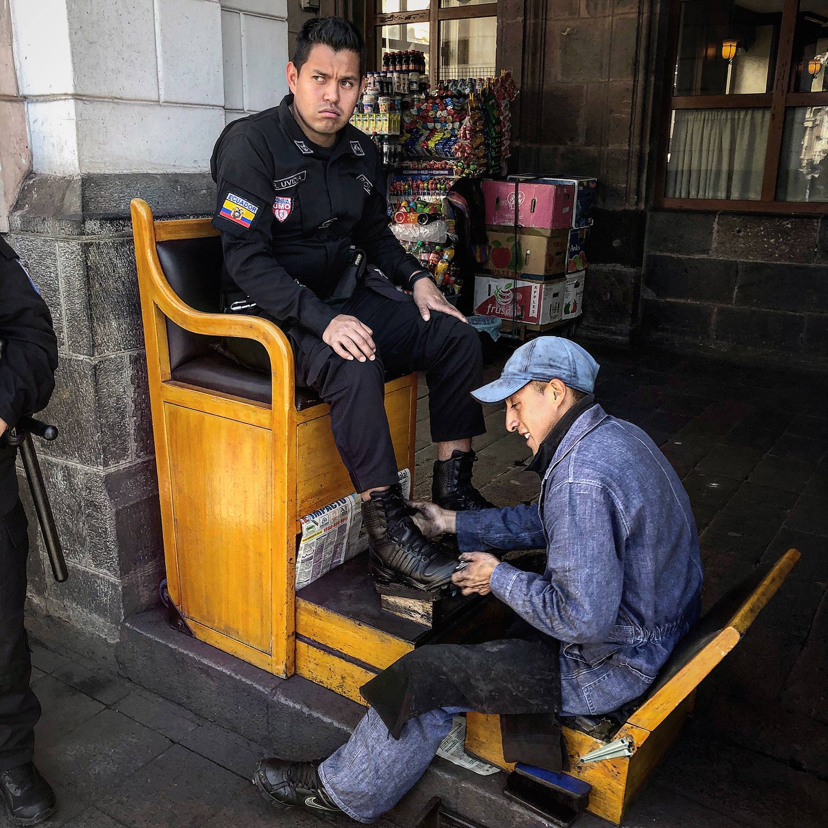 an ecuadorian policeman gets his shoes shined a plaza de la indepencia in quito