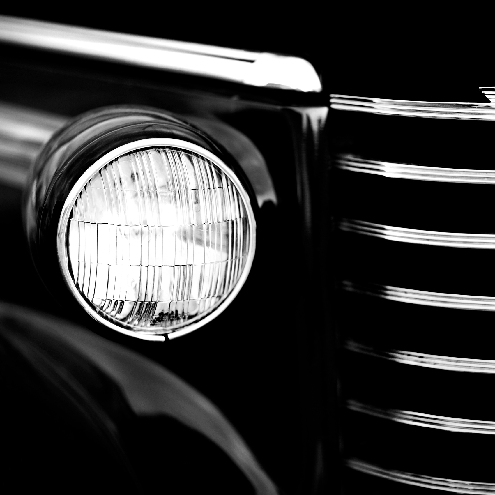 a black and white photo of a head light on a 1946 oldsmobile automobile