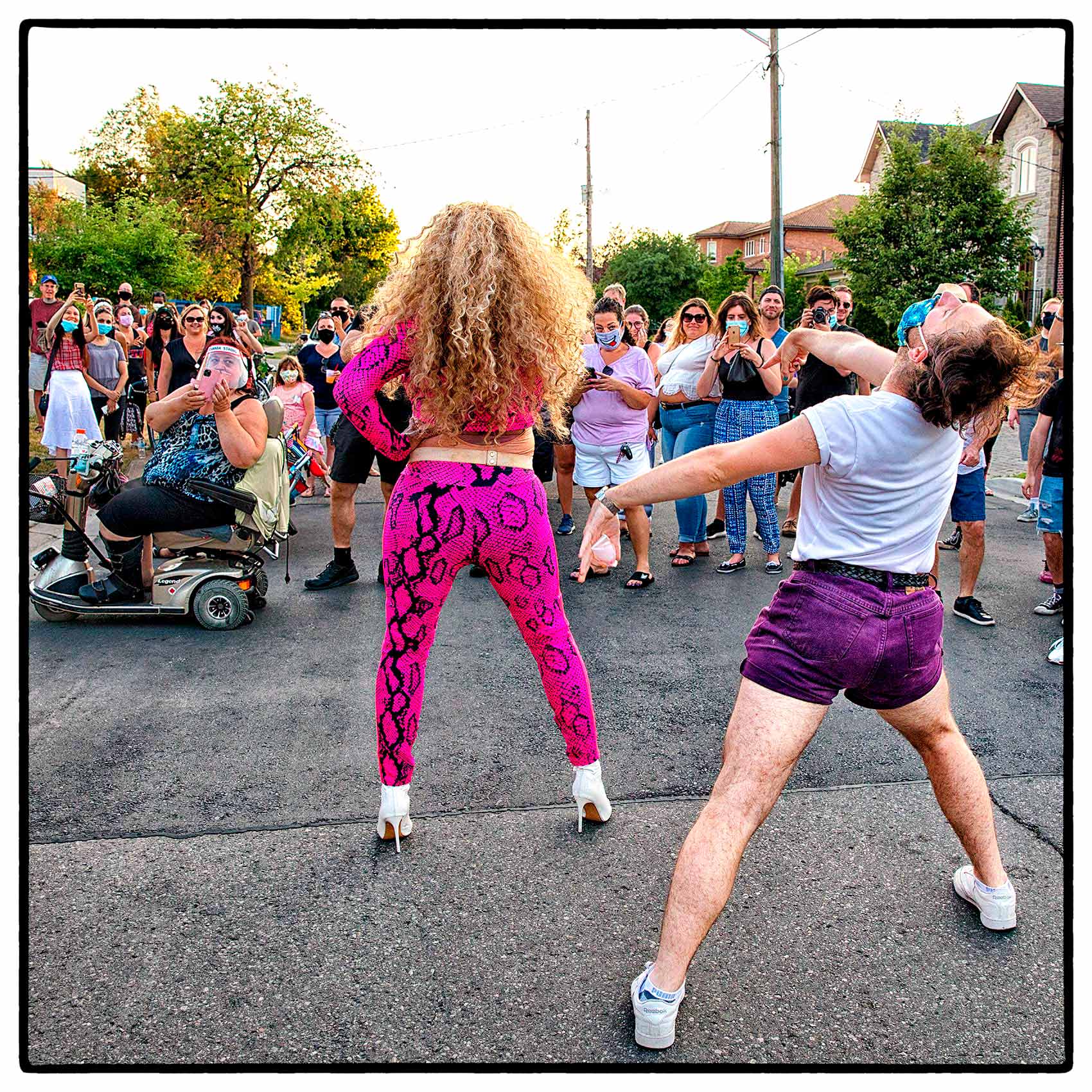 a man dancing behind a drag queen during a street show in north york in toronto