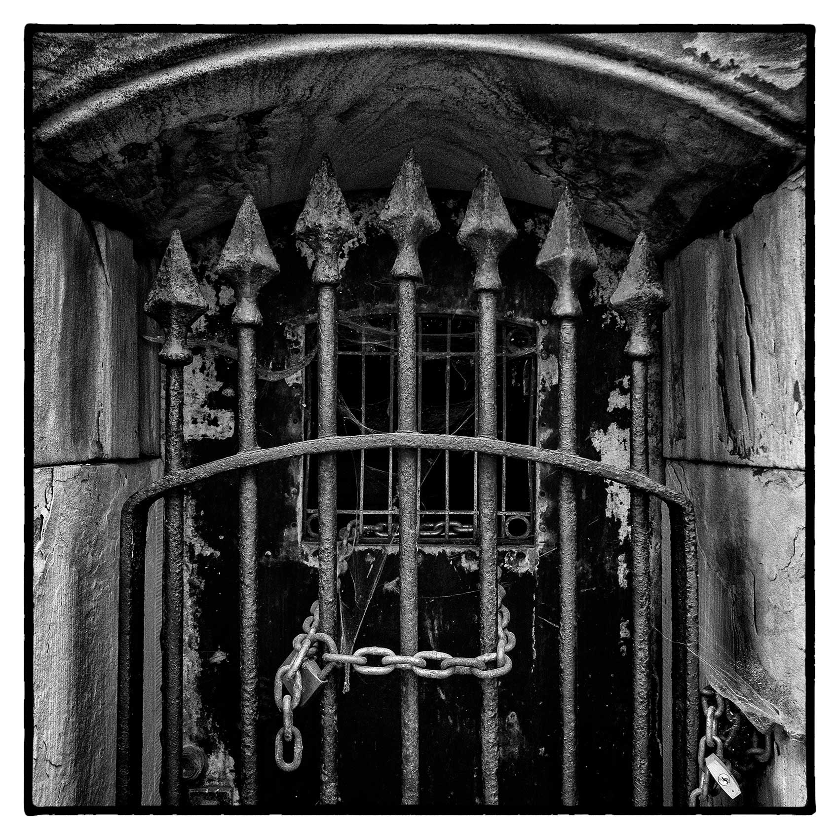a locked up old iron gate to a crypt at Torontos St. James Cemetery