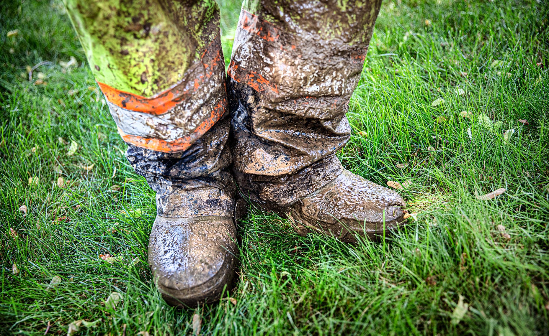 a toronto construction worker shows off his muddy boots to a photographer 