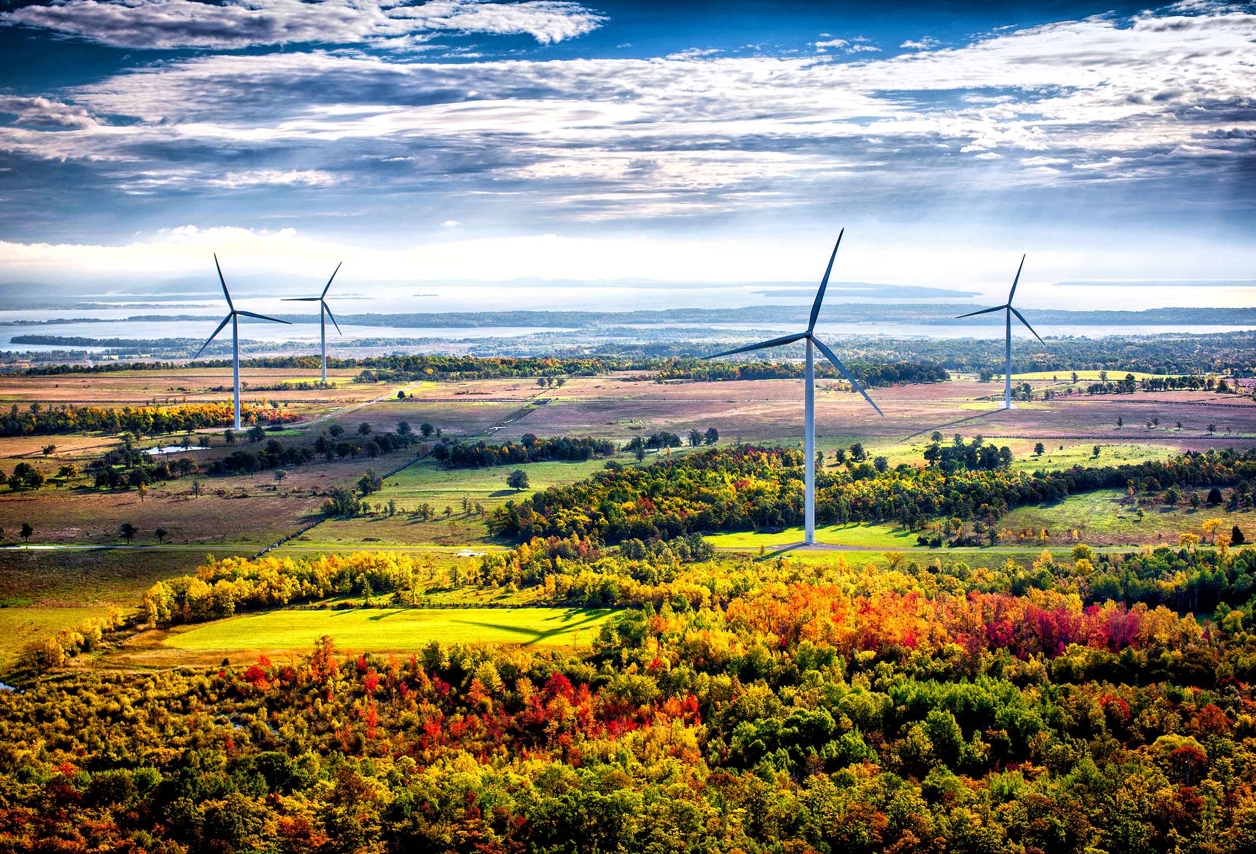 the sun rises over the industrial  ge northland power wind turbines on manitoulin island canada