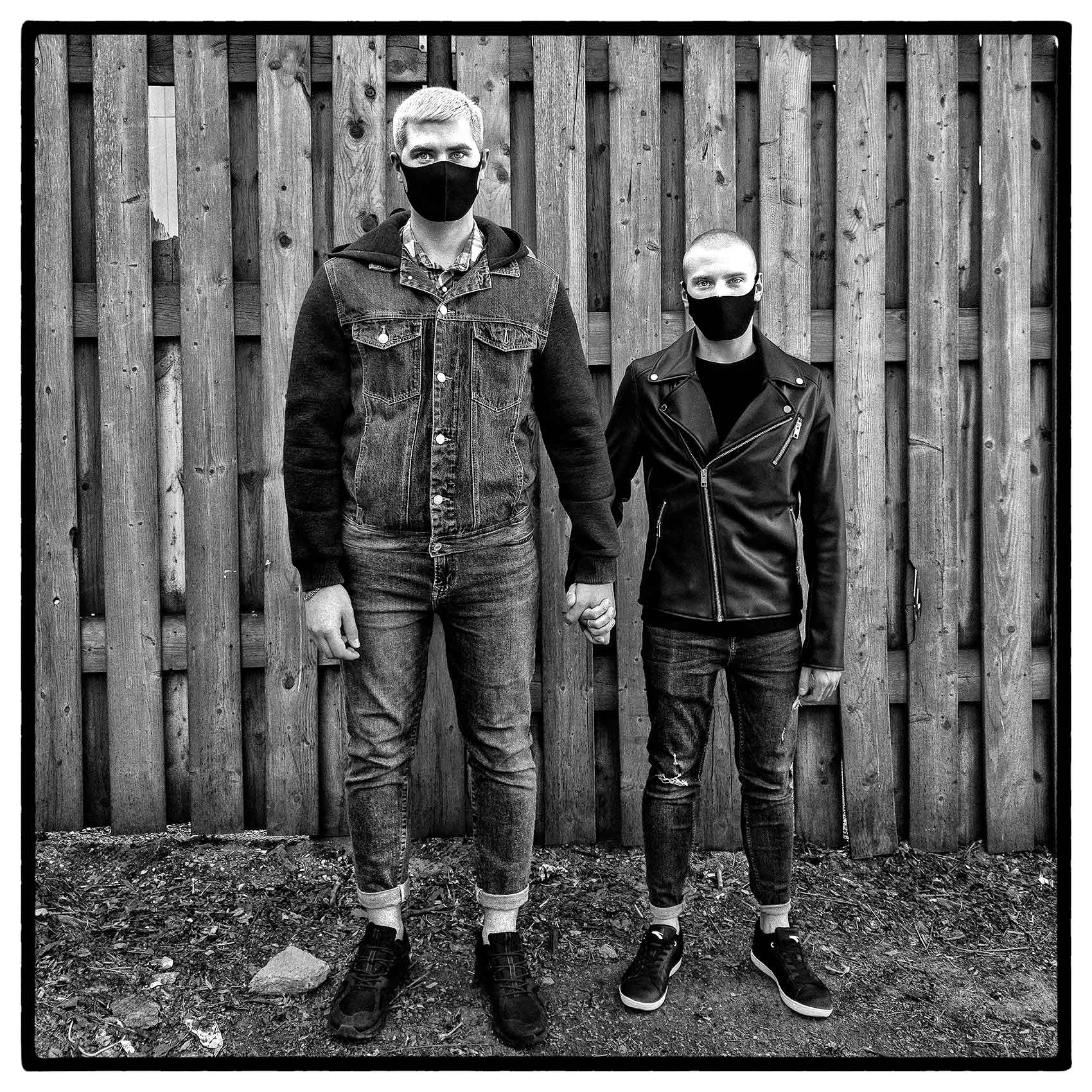 a portrait of a unique looking toronto  gay couple wearing face masks during the pandemic