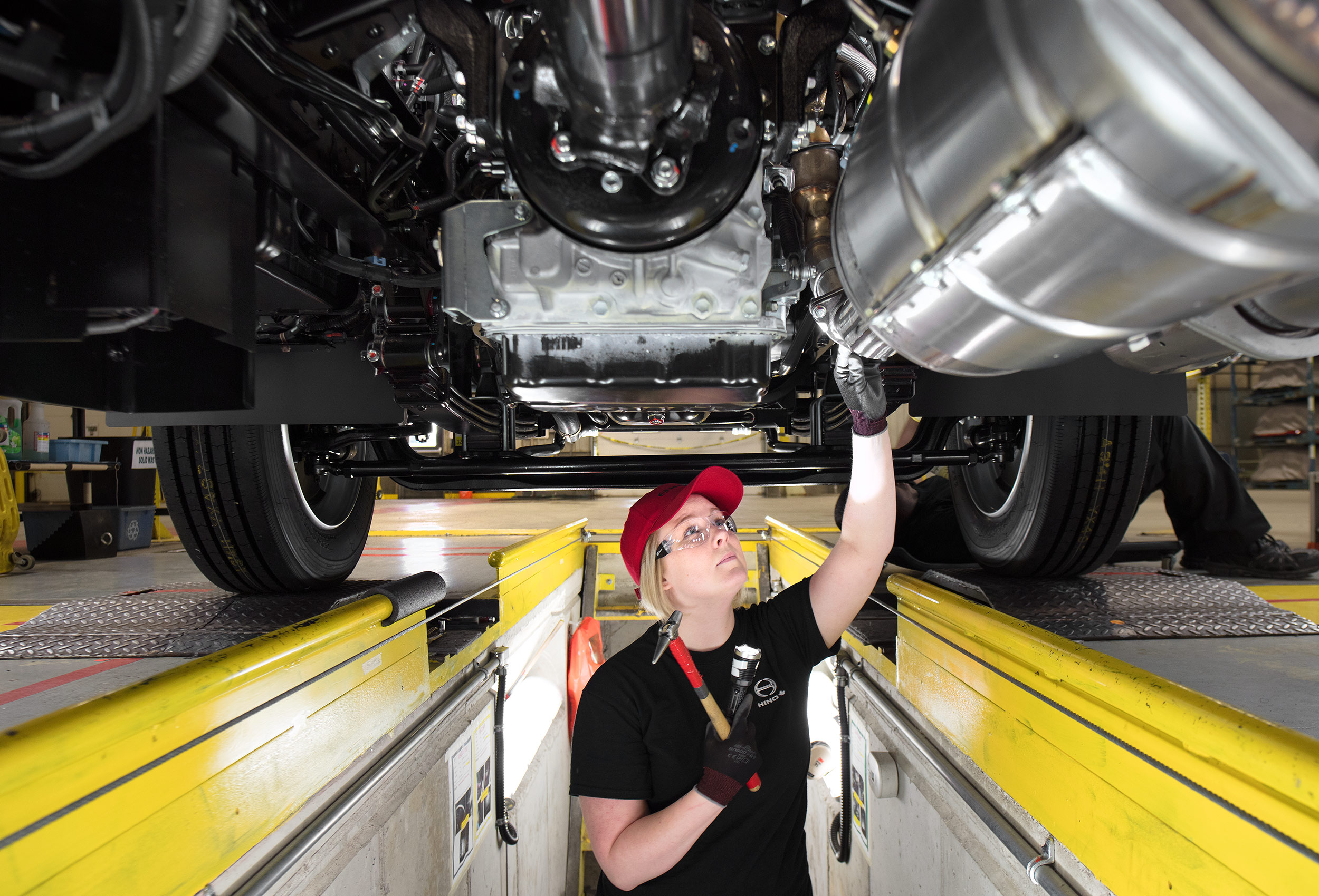 a factory worker inspects a hino m series truck at their woodstock ontario plant