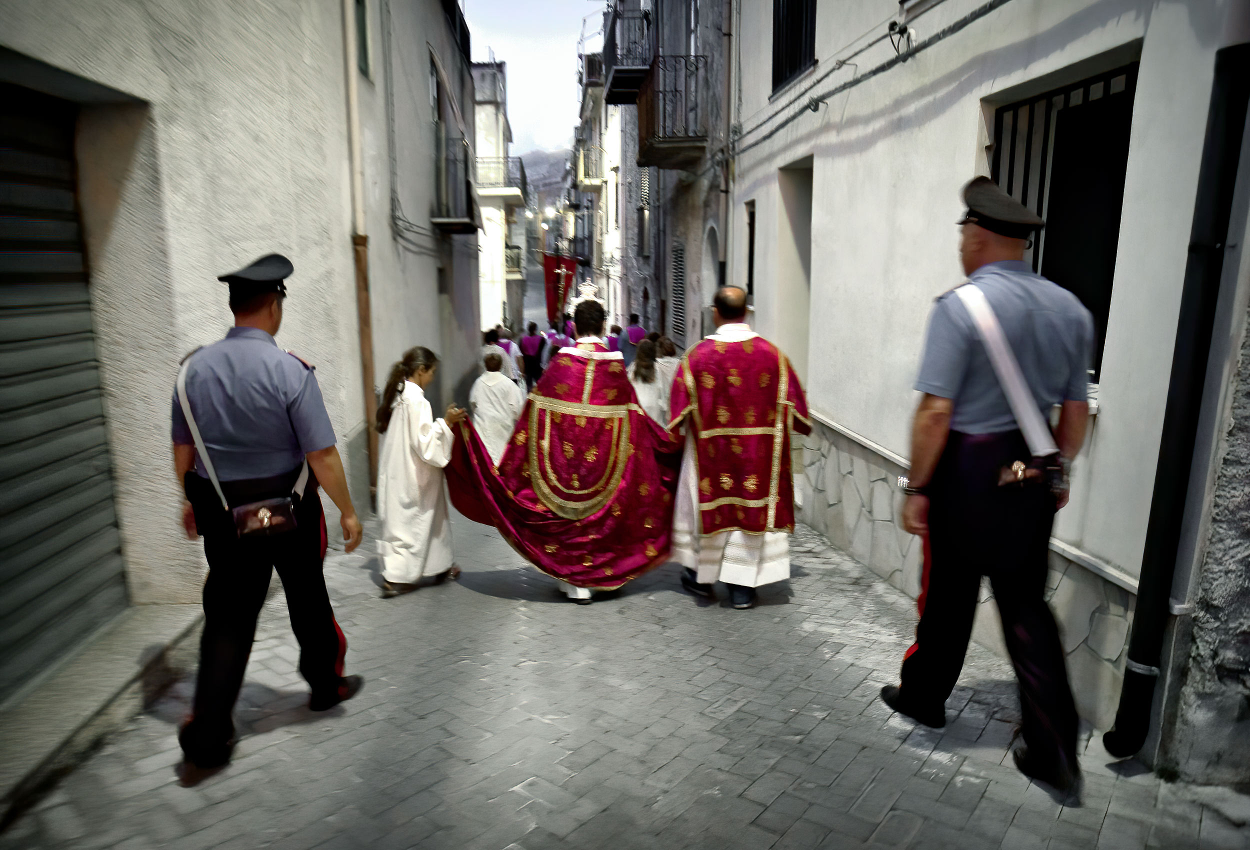 two policeman escort catholic priests during a religious festival in graterri sicily