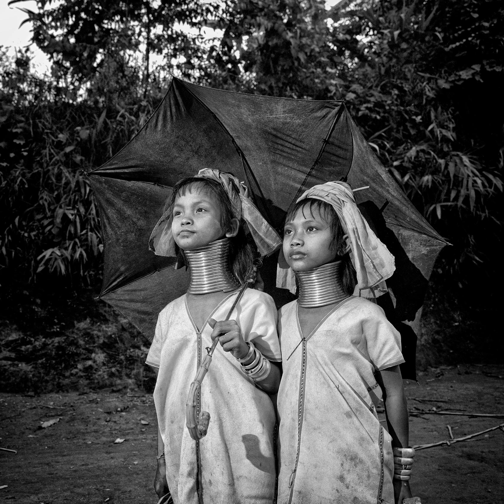 two-young-girls-from-the-long-neck-karen-hill-tribe-pose-for-a-photo-in-northern-thailand